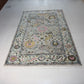 Decorative rug with floral patterns on a white tiled floor