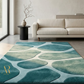 Modern living room with a blue and green patterned rug, beige sofa, and side table.