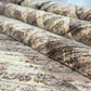 Close-up of textured fabric with a camouflage pattern on a wooden surface.