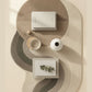 Round woven coffee table with decorative items on a neutral background
