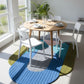 Dining area with a round wooden table and white chairs on a colorful geometric rug.