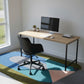 Modern home office with a wooden desk, chair, and computer setup.