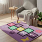 Children's rug with numbers and shapes in a room with a chair and small table.