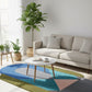 Colorful geometric rug in a modern living room with a sofa and coffee table.