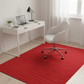 Modern home office with a white desk, chair, and red rug.