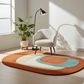 Round multicolored rug on a wooden floor with a chair, plant, and lamp in a bright room.