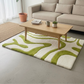 Living room with a green and white patterned rug, wooden coffee table, and beige sofa.