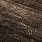 A close-up of a dark brown textured rug with a subtle woven pattern, featuring a small gold 'R' logo in the bottom right corner.