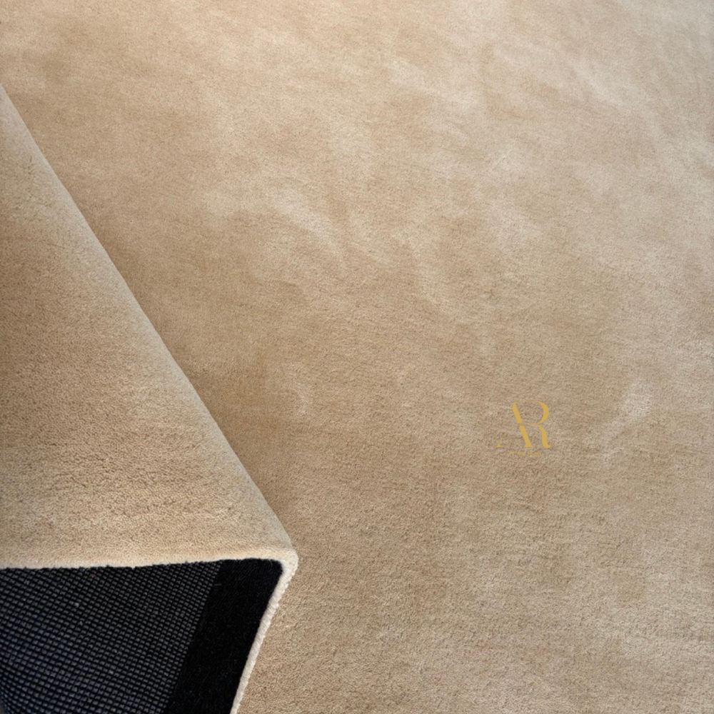 Close-up of a beige textured rug with a brand logo.