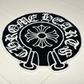 Round black and white rug with a floral design and text on a tiled floor.