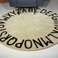 Beige patterned Alphabetical rug on a floor