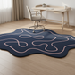Blue abstract rug with pink lines in a room with a desk and chair.