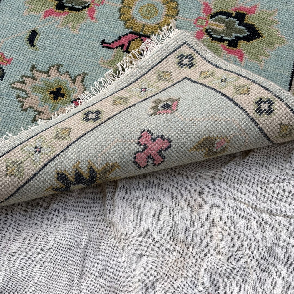 Close-up of a floral-patterned rug on a textured surface