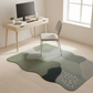 Modern office setup with a desk, chair, and unique green rug on a light wooden floor.