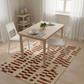 Dining room with a wooden table and chairs on a patterned rug.