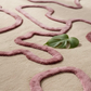 Pink wavy pattern on a beige background with a green leaf