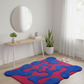 Modern room with a colorful abstract rug, wooden console table, and plants.
