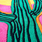 Colorful abstract pattern with green, pink, orange, and black lines on a textured surface.