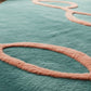 Teal rug with pink circular patterns