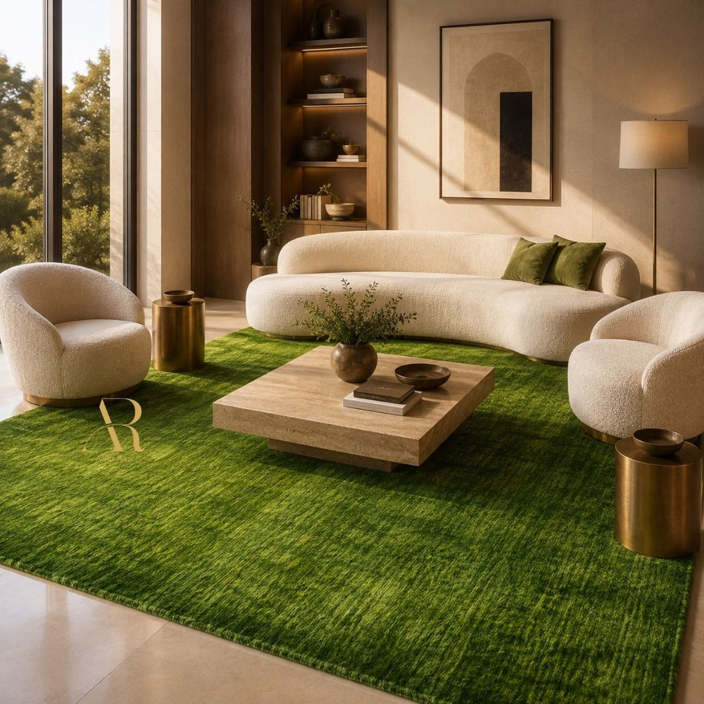 A rectangular green artificial turf or grass mat with a textured grass-like surface, laid out on a light-colored tiled floor. A gold monogram logo reading 'AR' is printed near one corner.