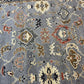 Close-up of a patterned rug with intricate designs on a gray background