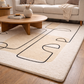 Beige rug with black abstract patterns in a living room setting