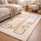 Beige rug with abstract black designs in a bedroom setting