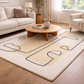 Living room with a beige rug featuring abstract patterns, a wooden coffee table, and a white sofa.