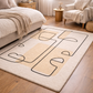 Beige and brown abstract patterned rug in a bedroom setting with furniture.