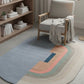 Colorful rug with geometric pattern in a room with a chair and bookshelf.