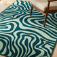 Green and blue wavy patterned rug with a chair on a wooden floor