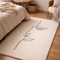 Beige rug with abstract line art in a bedroom setting