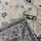 Close-up of two patterned rugs with intricate designs on a neutral background.