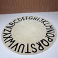 Beige patterned Alphabetical rug on a floor