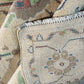 Close-up of a patterned rug with intricate designs and fringes.