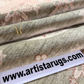 Close-up of textured rugs with a visible brand name tag displaying 'www.artistarugs.com'.