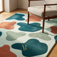 Colorful abstract rug with a brand logo on a wooden floor.