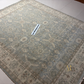 Patterned rug on a tiled floor with a label attached