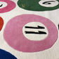 Close-up of colorful circular patterns with numbers on a textured surface.