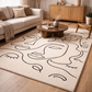 Living room with a decorative rug featuring abstract designs, a sofa, and wooden furniture.