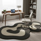 Modern home office with a desk, chair, and decorative rug.