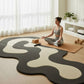 Woman practicing yoga on a modern rug in a bright room.