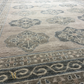Close-up of a patterned rug with geometric designs in gray and beige tones.