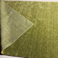 An olive green textured area rug with a small gold monogram logo in the lower right corner, displayed flat against a white background.