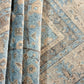Close-up of a patterned rug with blue and beige colors