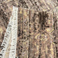 Close-up of a textured rug with fringes on a neutral background