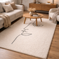 Living room with a beige rug, wooden coffee table, and neutral-colored furniture.