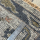 Close-up of a patterned rug with a ruler for scale
