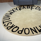 Beige patterned Alphabetical rug on a floor