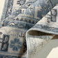 Close-up of a blue and beige patterned rug with a textured edge.